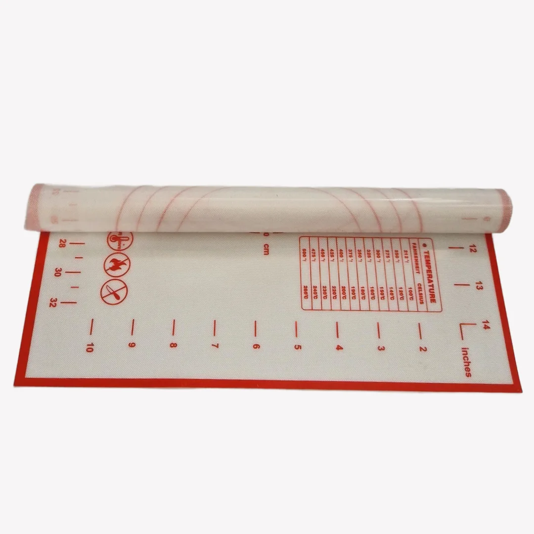 Ihoprullad vit bakmatta i silikon med rrött tryck. Mattan har både centimeter- och tumskalor längs kanterna. På mattan syns en temperaturkonverteringstabell och en omvandlingstabell för mått. Längst ner syns symboler som visar att mattan tål diskmaskin, tål ugn och inte bör skäras på.