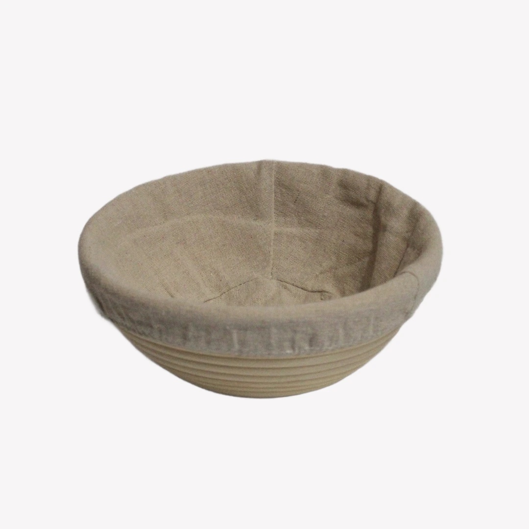 jaskorg_rund_20cm_3_rgba En rund jäskorg 20 cm i rotting med tygöverdrag. Jäskorgen är placerad på en vit bakgrund.