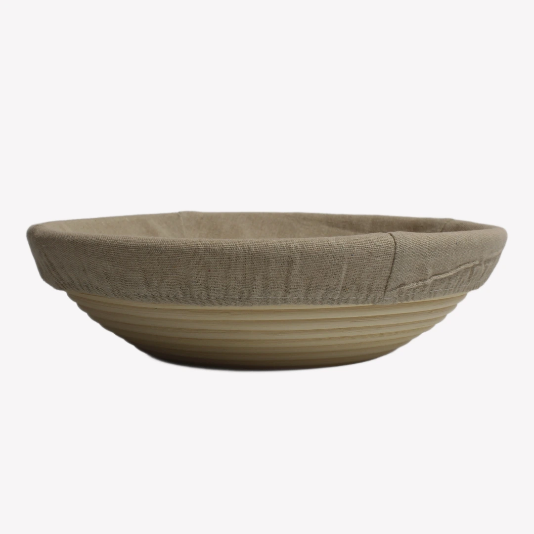 jaskorg_rund_30cm_rgba En rund jäskorg 30 cm i rotting med tygöverdrag. Jäskorgen är placerad på en vit bakgrund.