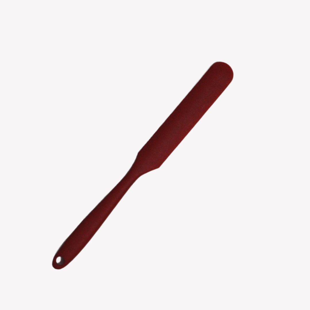 slickepott_avlang_24cm_rgba En röd avlång slickepott på 24 cm med smalt handtag och avlångt blad. Slickepotten ligger på en vit bakgrund.