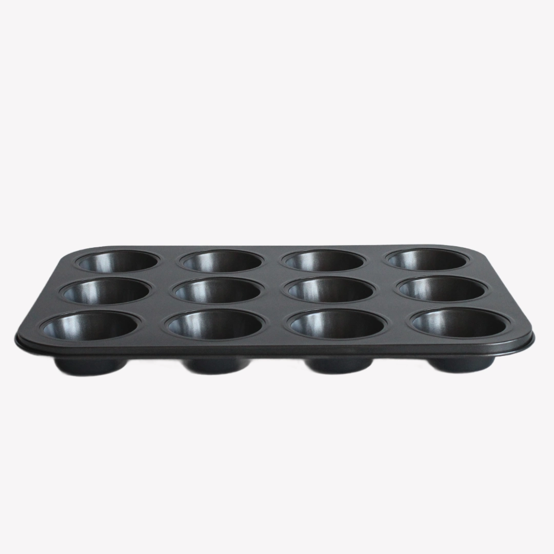 Muffinsform_12st_svart Svart muffinsform med non-stick beläggning, plats för 12 muffins, mot en vit bakgrund.