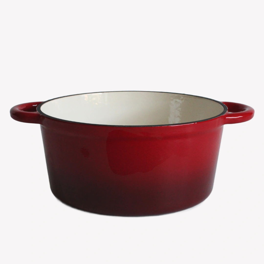 Grön gjutjärnsgryta utan lock. Grytan har en blank emaljerad utsida och en vit emaljerad insida. Grytan står på en ljusgrå bakgrund.