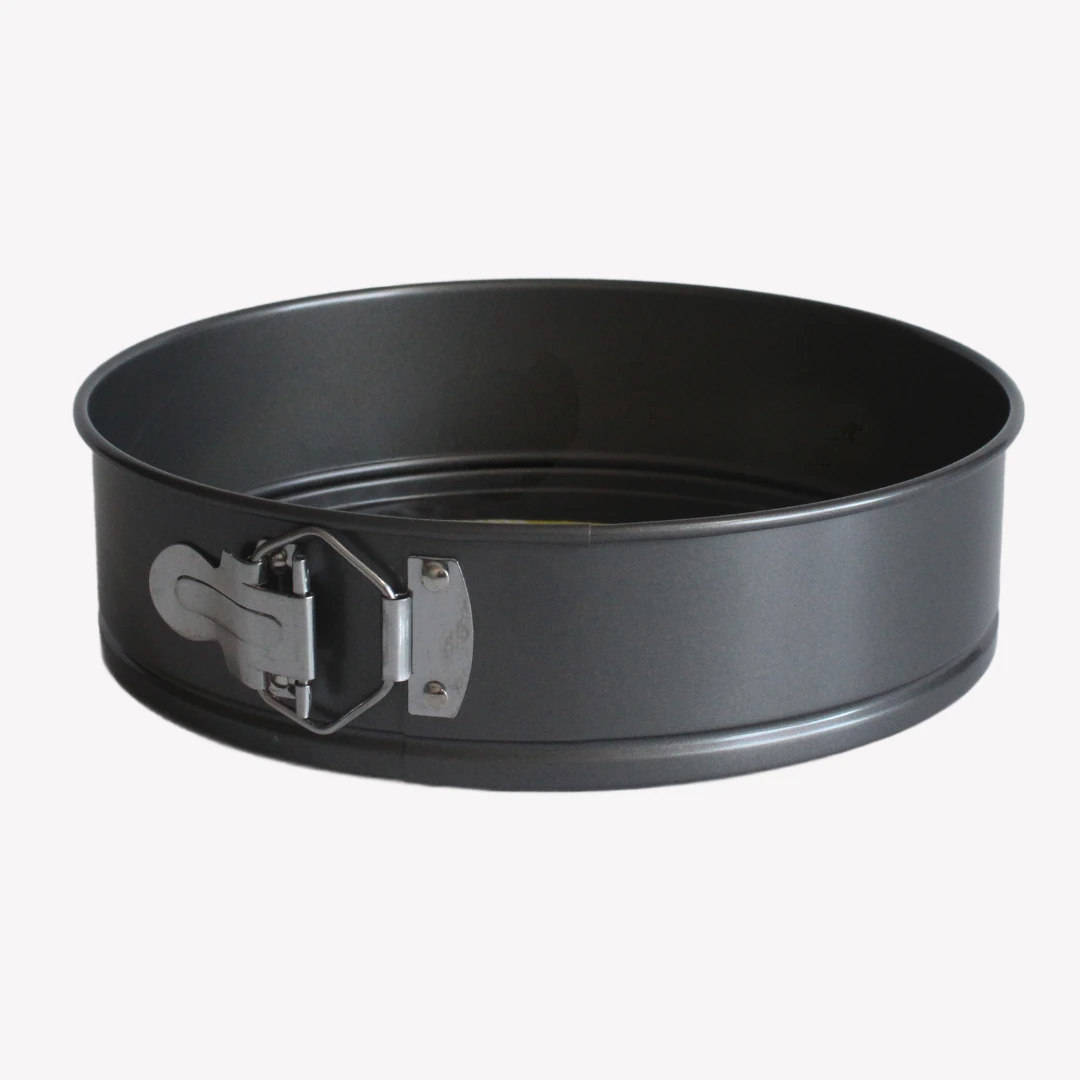 springform_24cm_2 Svart springform 24 cm med non-stick beläggning, löstagbar botten och metallspänne. Springformen ligger på en vit bakgrund