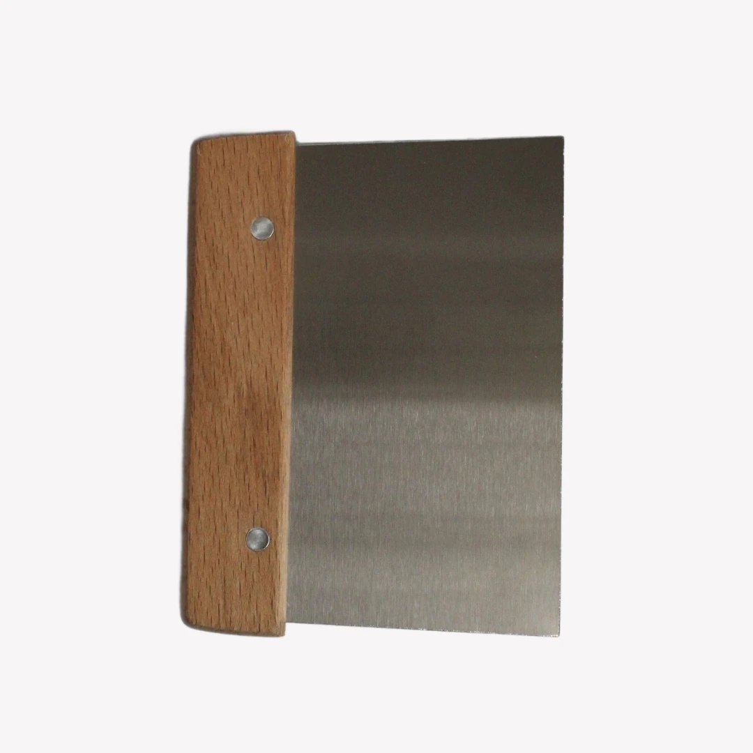 Degskrapa_tra_2 En degskrapa i rostfritt stål med ett trähandtag. Degskrapan ligger på en vit bakgrund.