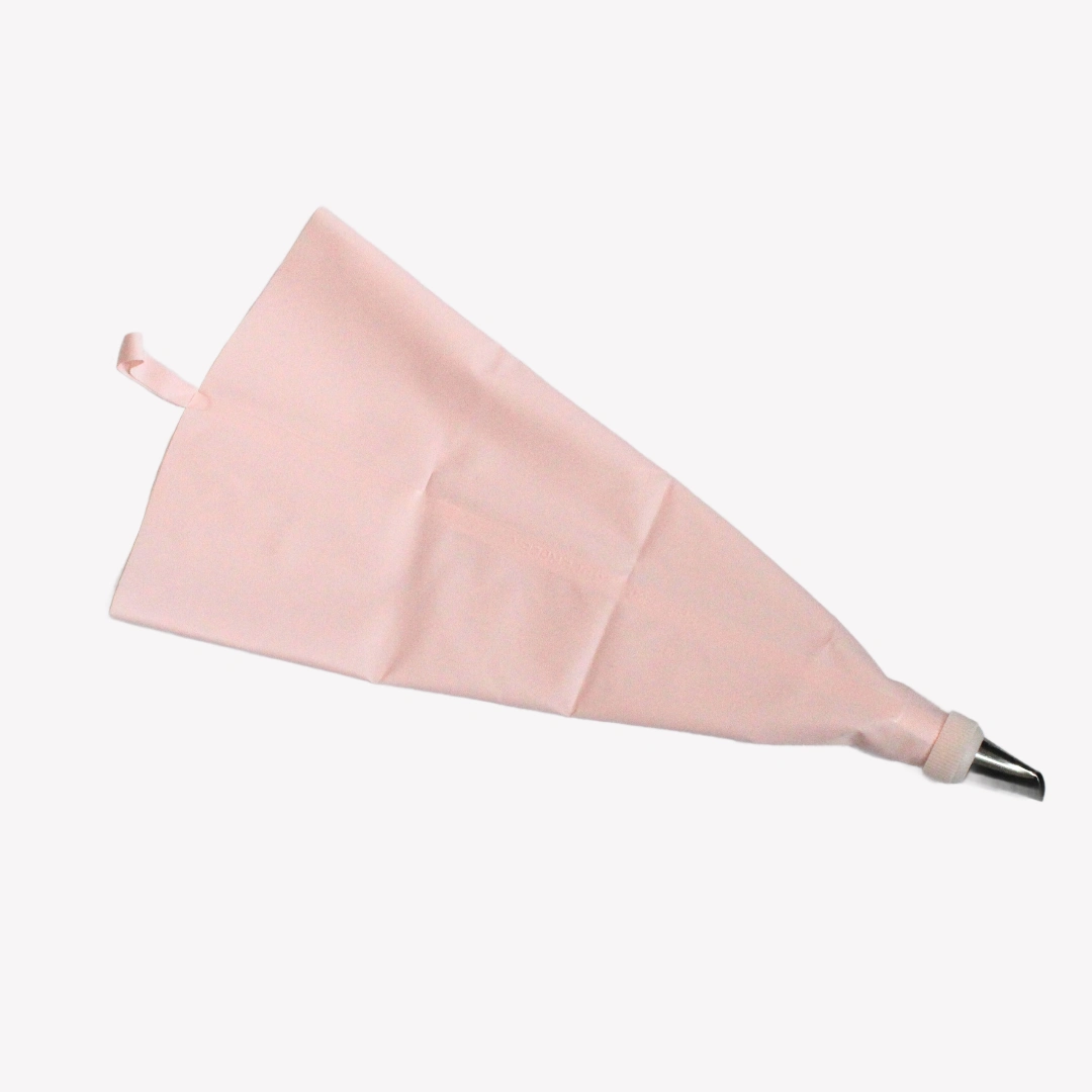 Spritsset_silikon_rosa_2 En rosa spritspåse med metalltyll ligger på en vit bakgrund. Spritspåsen har en ögla för upphängning.