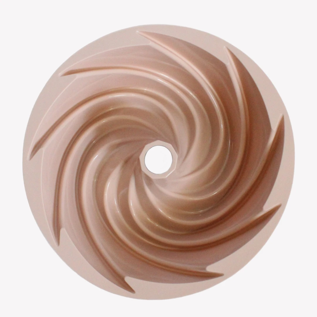 sockerkaksform_silikon_spiral_rosa_3 En rosa sockerkaksform i silikon sedd uppifrån, med en spiralformad insida och ett hål i mitten. Designen skapar ett snurrande mönster som liknar en virvelvind.