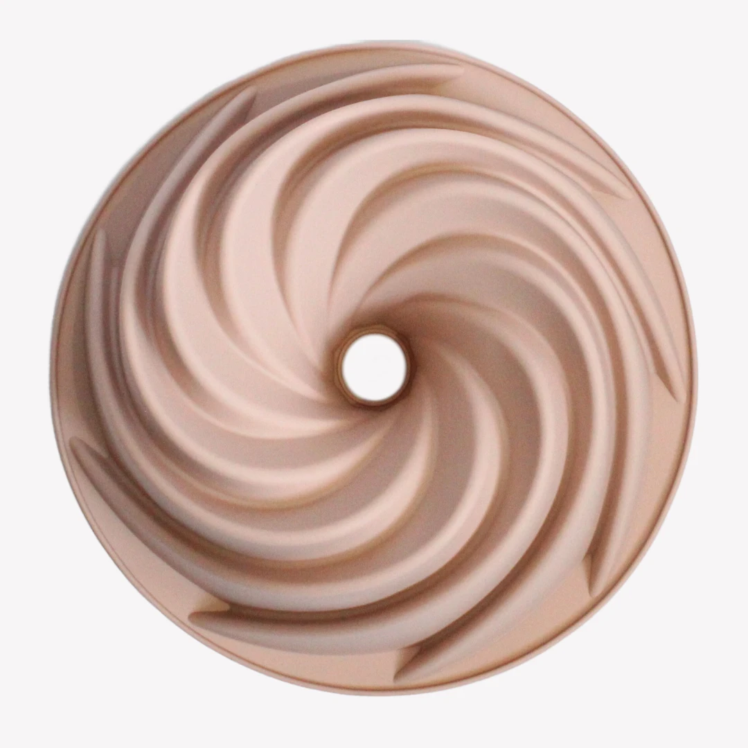 sockerkaksform_silikon_spiral_rosa_4 En rosa sockerkaksform i silikon sedd uppifrån, med en spiralformad utsida och ett hål i mitten. Designen skapar ett snurrande mönster som liknar en virvelvind.